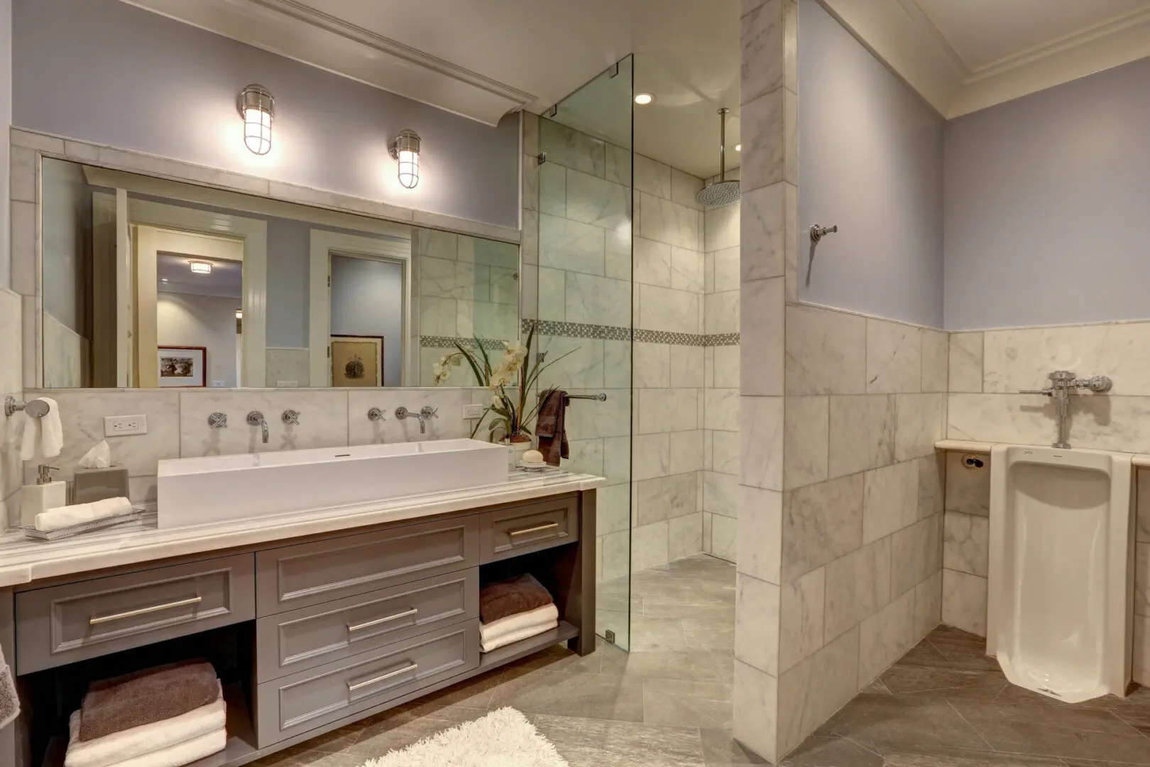 A bathroom with a large walk in shower and double vanity.
