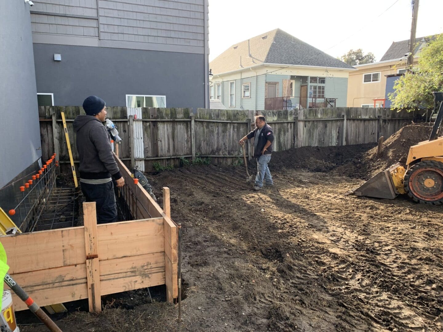 Two men are digging a hole in the ground.