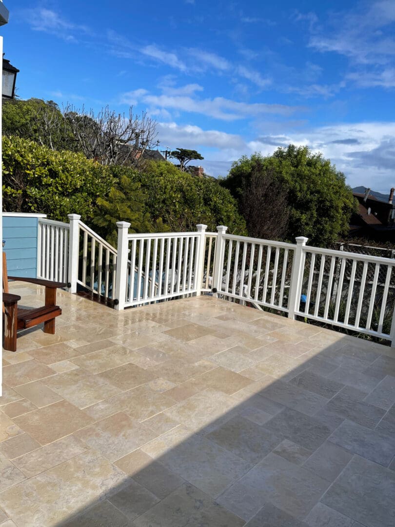 A deck with a bench and fence on top of it.