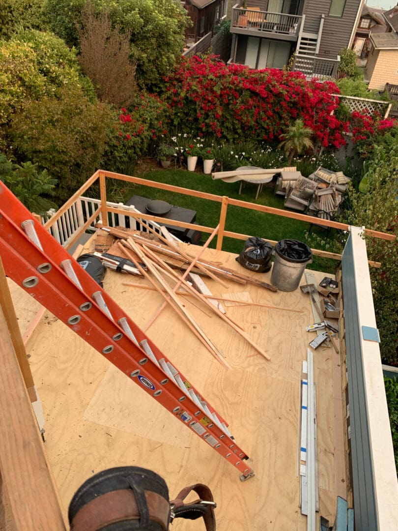 A ladder and some wood on the roof of a house