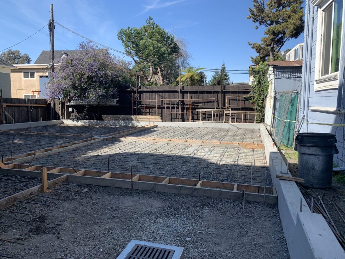 A backyard with concrete slab and a fence.