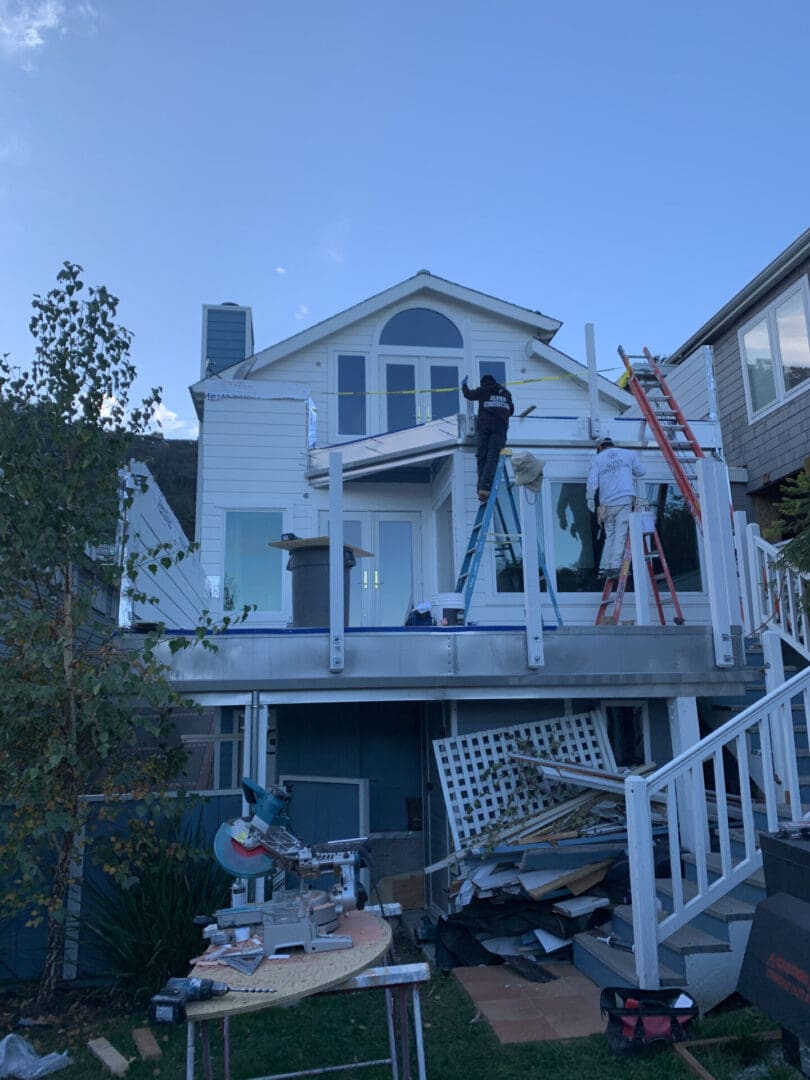 A house with many repairs and construction equipment on the front porch.