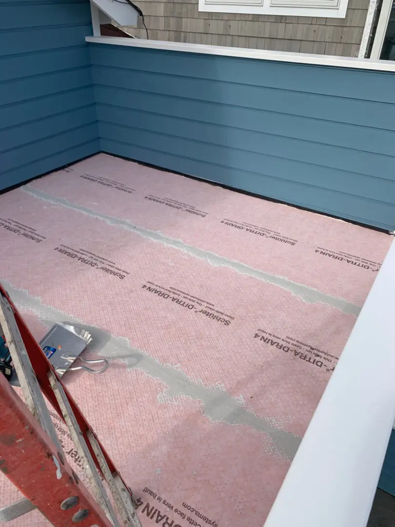 A pink sheet of insulation is laying on the floor.