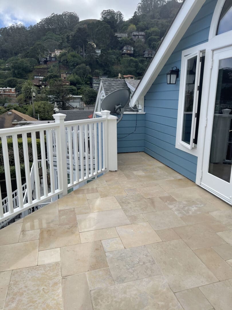 A balcony with a view of the ocean and mountains.