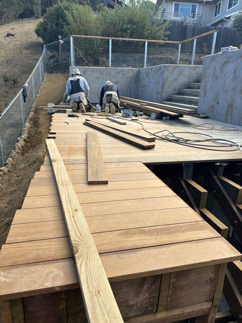 Two men working on a wooden deck.